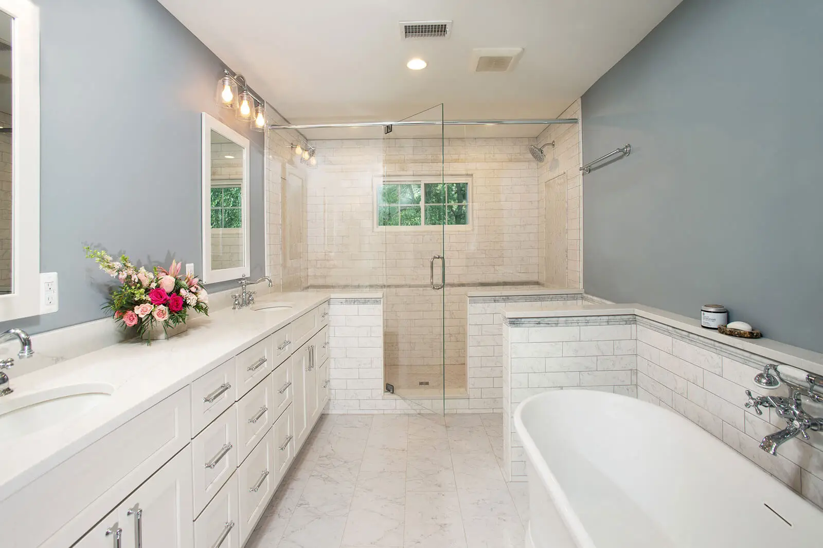 Modern bathroom featuring custom glass solutions with a frameless swinging glass shower enclosure designed for a bright and open feel.