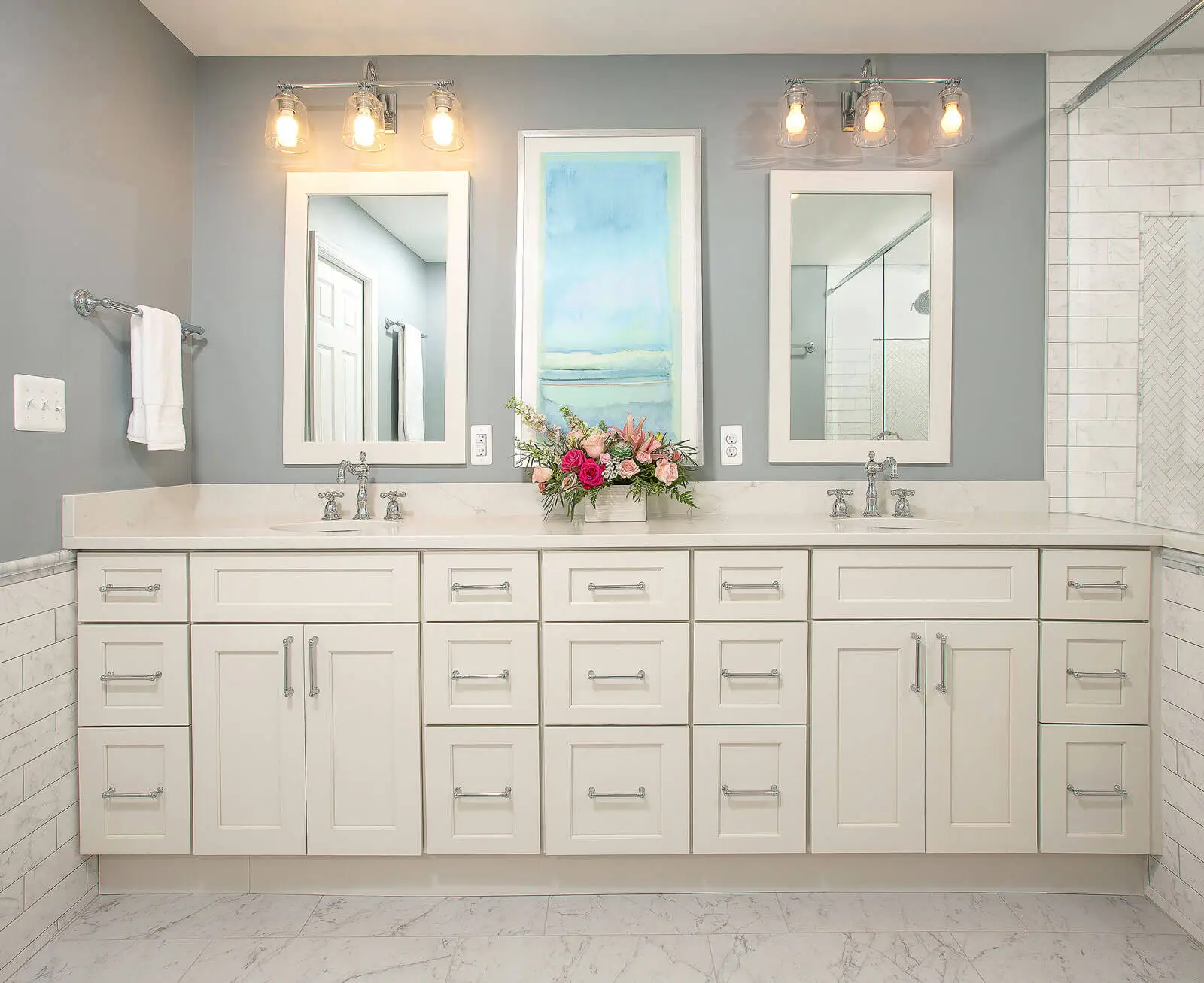 Modern double vanity with white cabinets, marble countertop, and decorative lighting