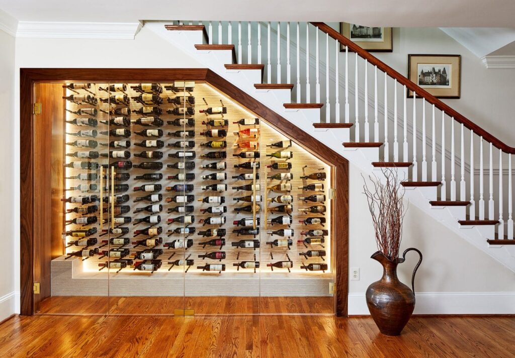 Elegant under-stair wine storage with a stylish swinging enclosure, creating a sophisticated and space-saving display.
